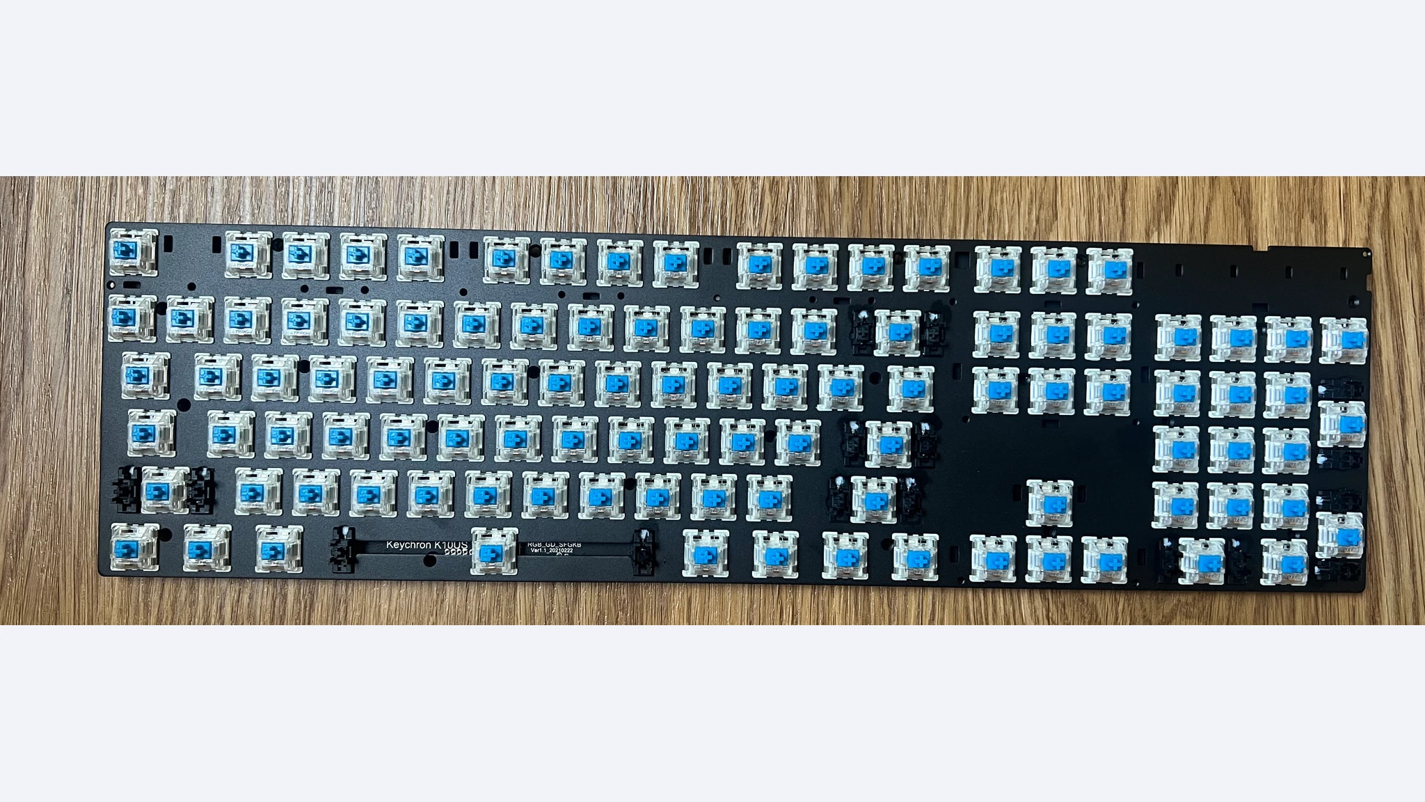 Disassembled Keychron K10 board with blue switches and removed keycaps and case
